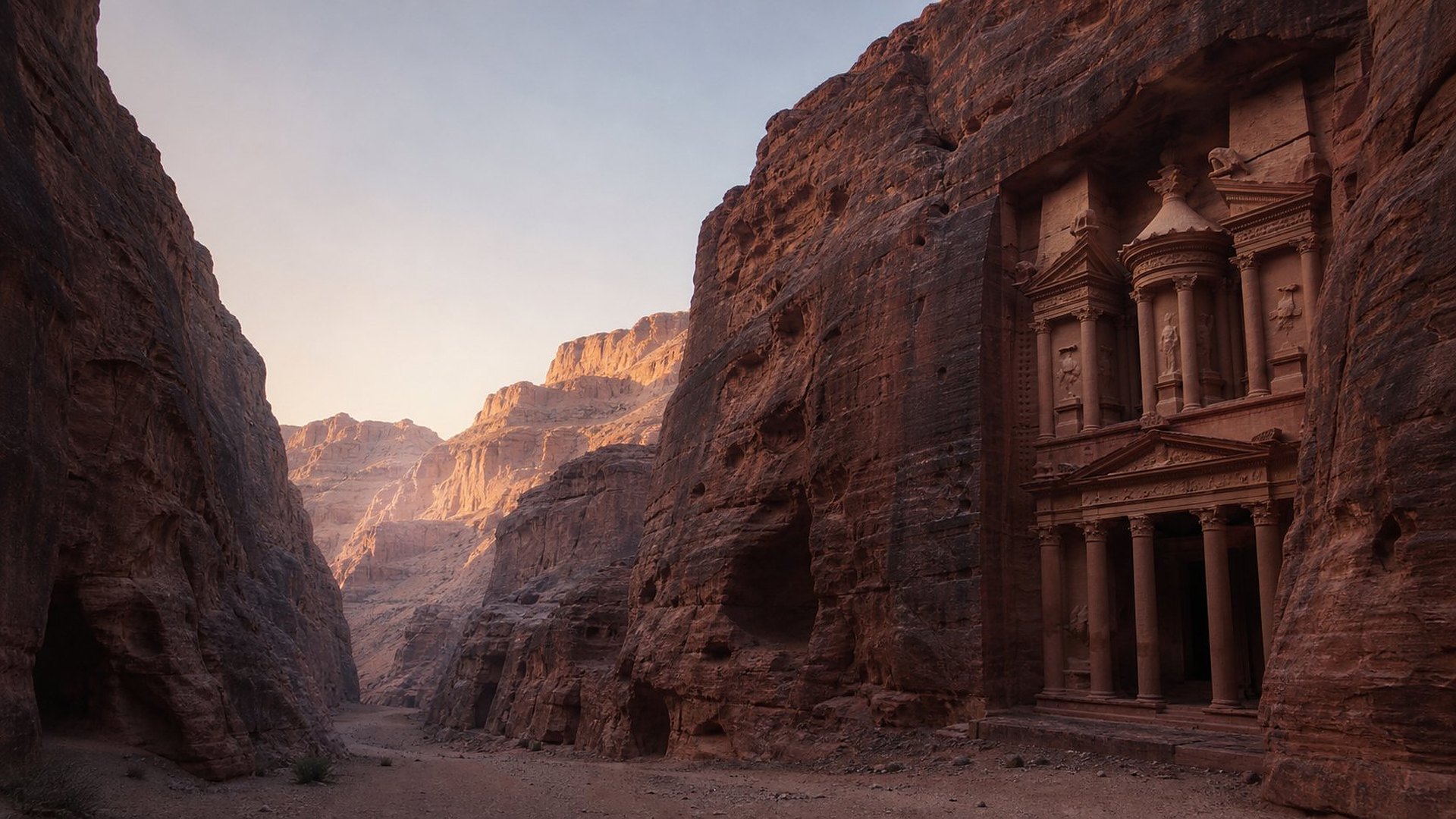 À l’aube, au fond d’une gorge étroite de grès rose, une façade monumentale à colonnes est taillée dans la falaise ; le lieu est entièrement désert.